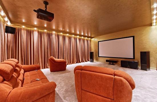 Red theatre curtains in Dubai complemented by a matching red sofa, creating a luxurious and elegant interior."